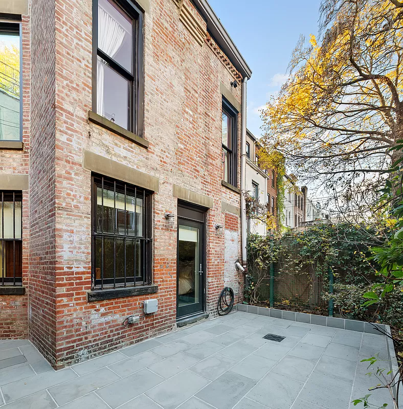 rear brick facade with a paved patio