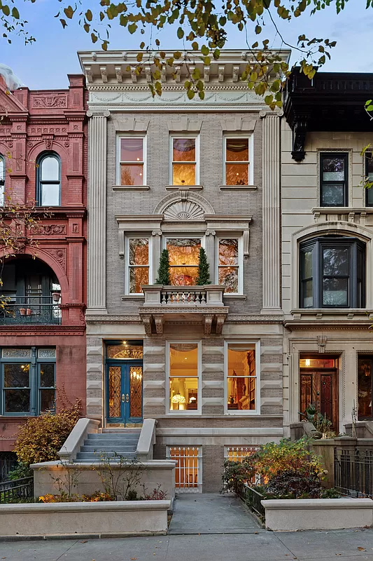 pale brick and limestone exterior with a stoop and a bracketed cornice