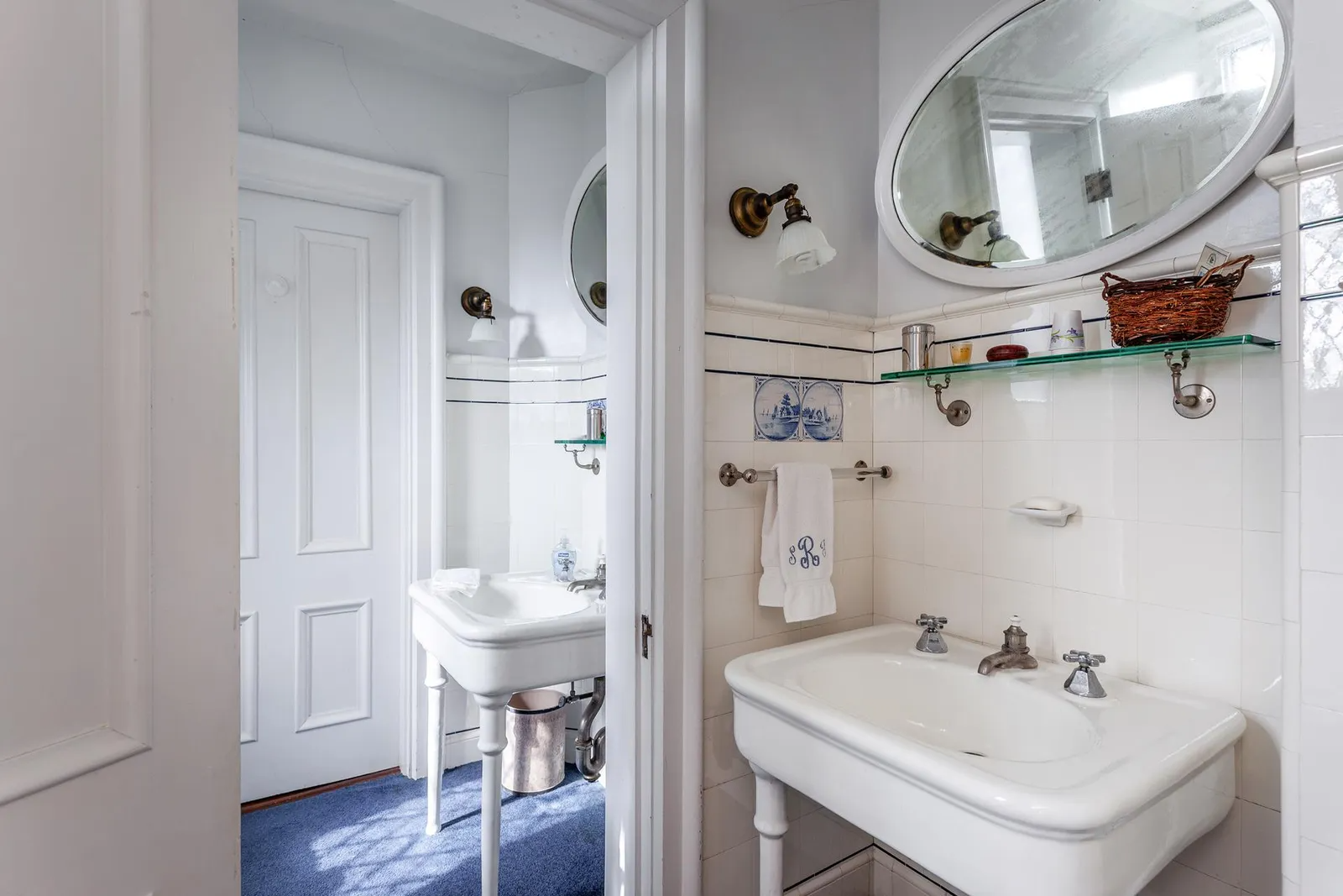 bathroom with white console sinks and delft accent tiles