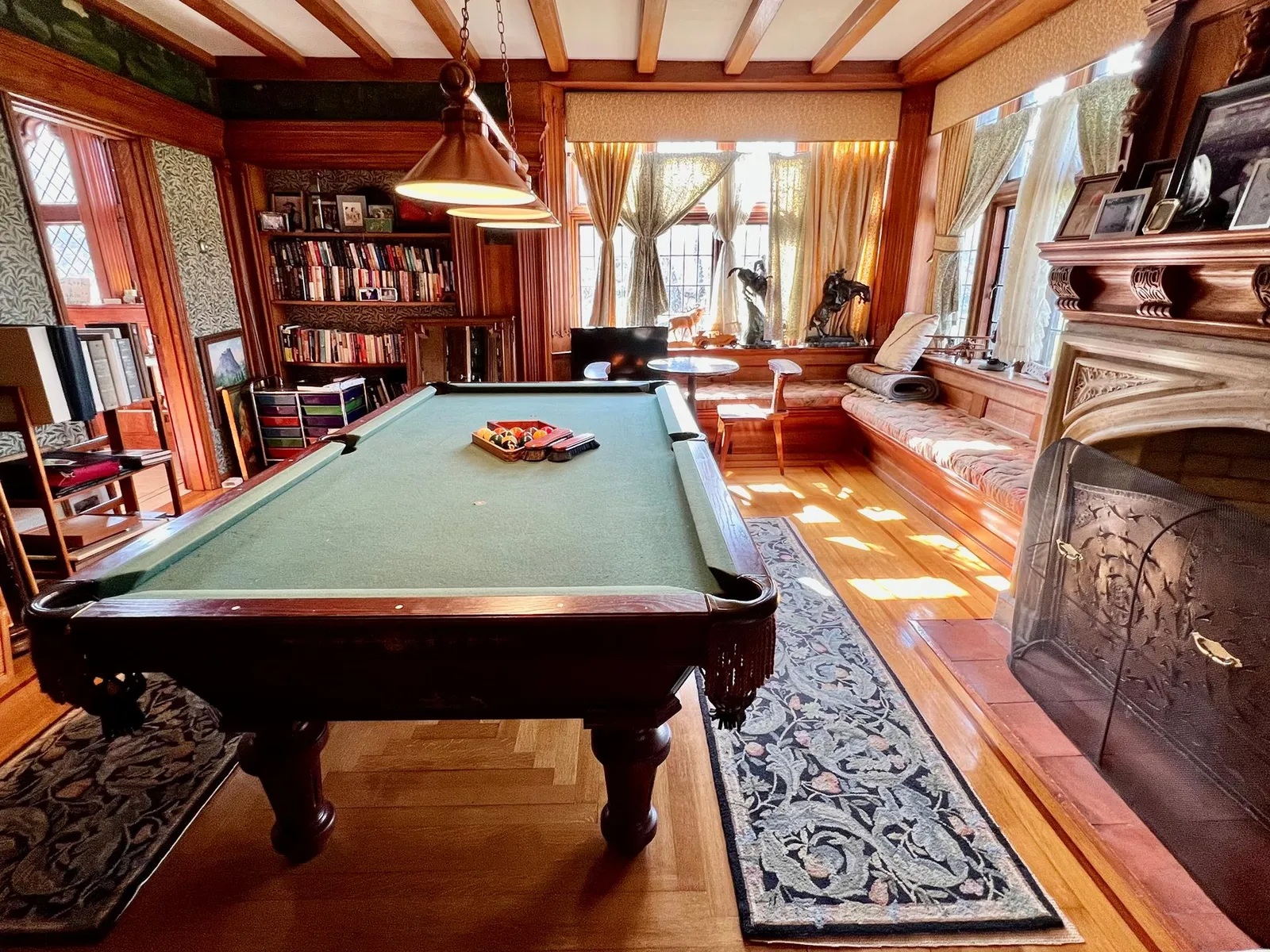 a billiard room with beamed ceiling and a fireplace