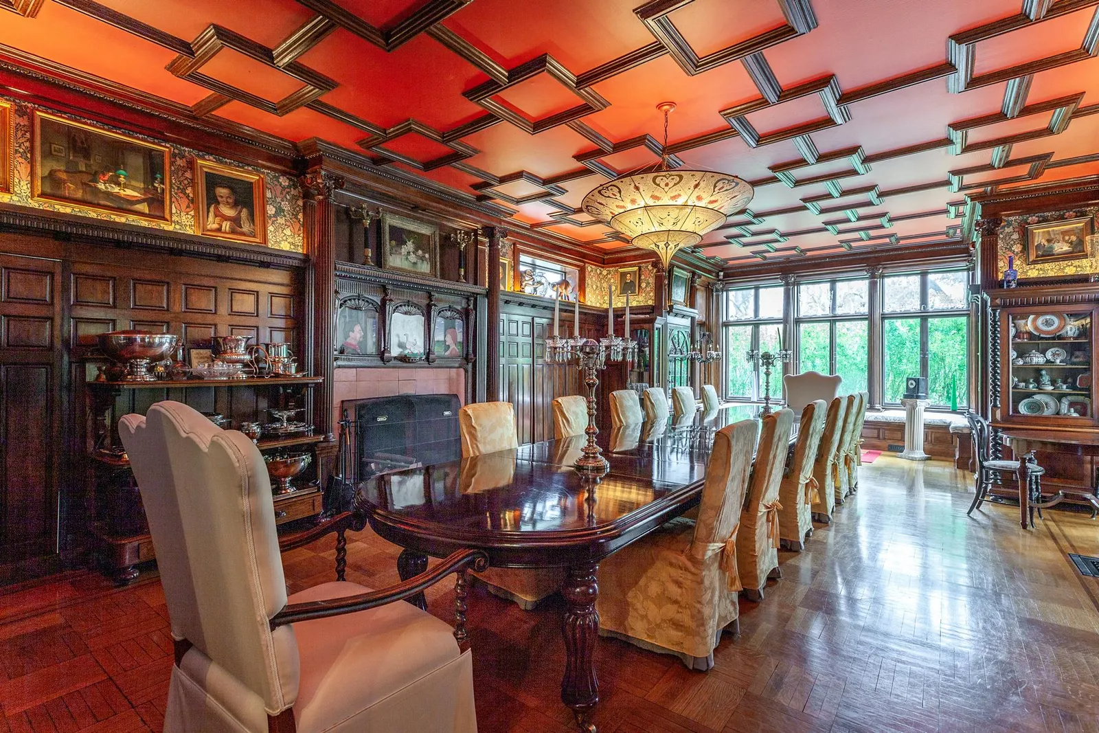 dining room with wood ornamented ceiling, wainscoting and a mantel with inset artwork