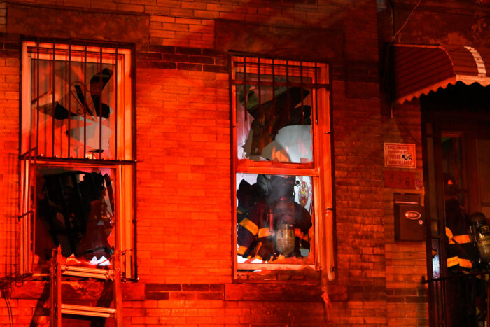 firefighters viewed through broken windows