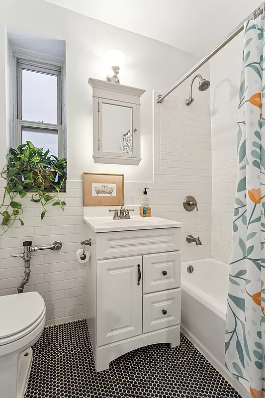 bathroom with black tile floor and white fixtures