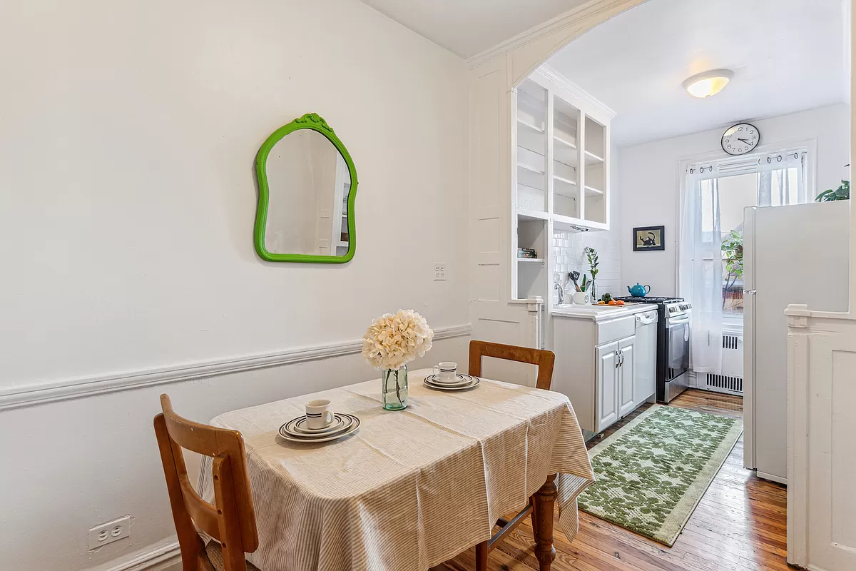 dining nook next to the kitchen with arched opening and wood floor