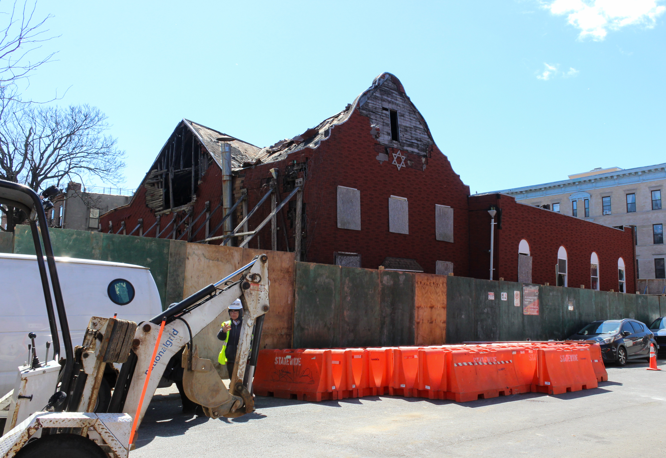 streetview of the synagogue on green avenue behind a construction fence