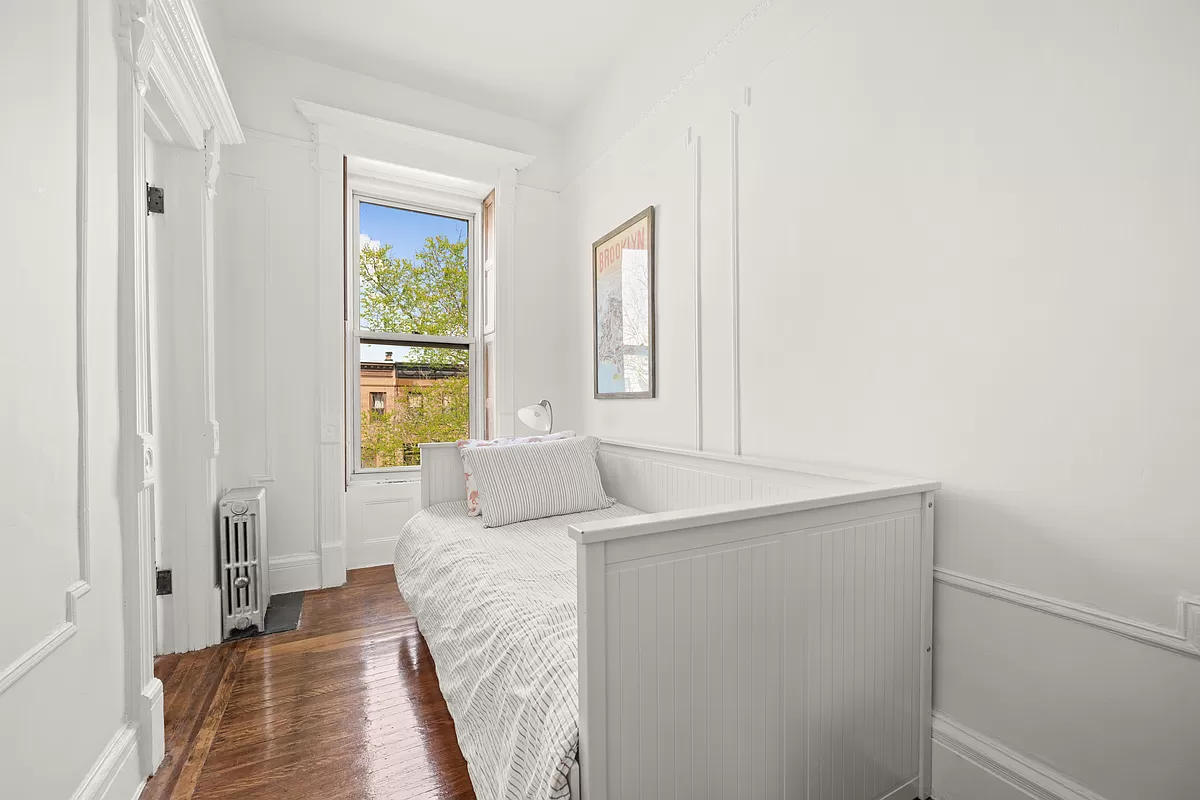 narrow bedroom with wood floor