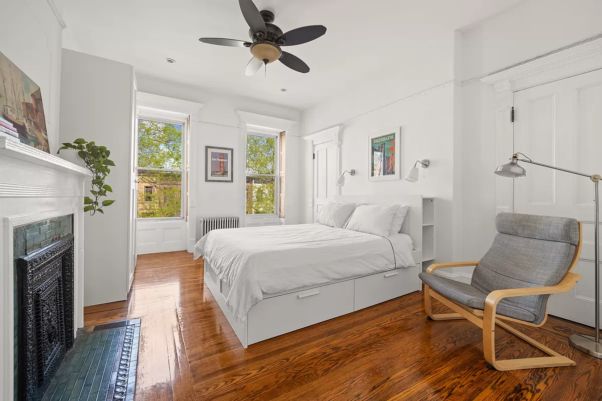 bedroom with wood floor, mantel