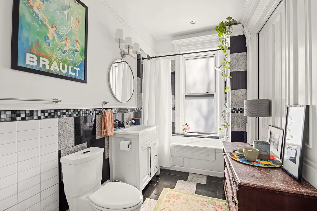 bathroom with black, white and gray tile and white fixtures