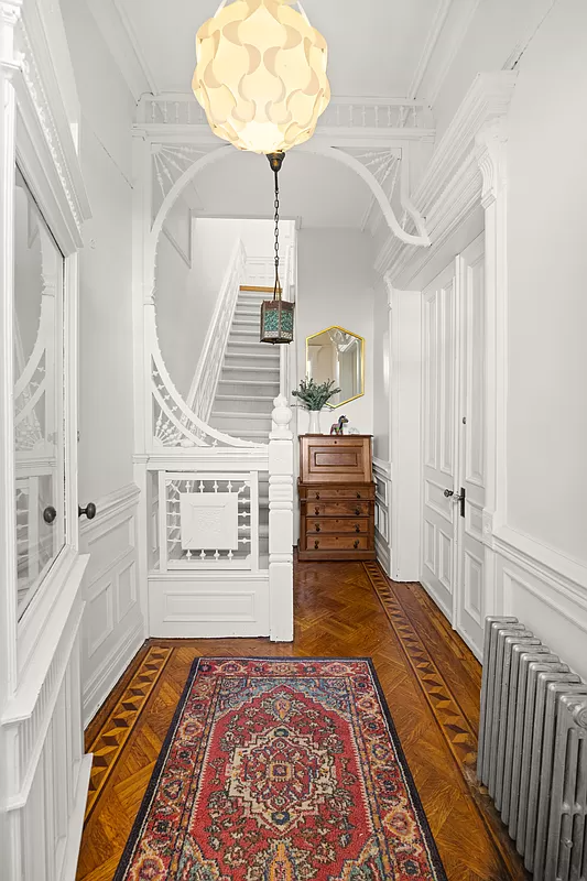 entry with fretwork, wainscoting, moldings all painted white