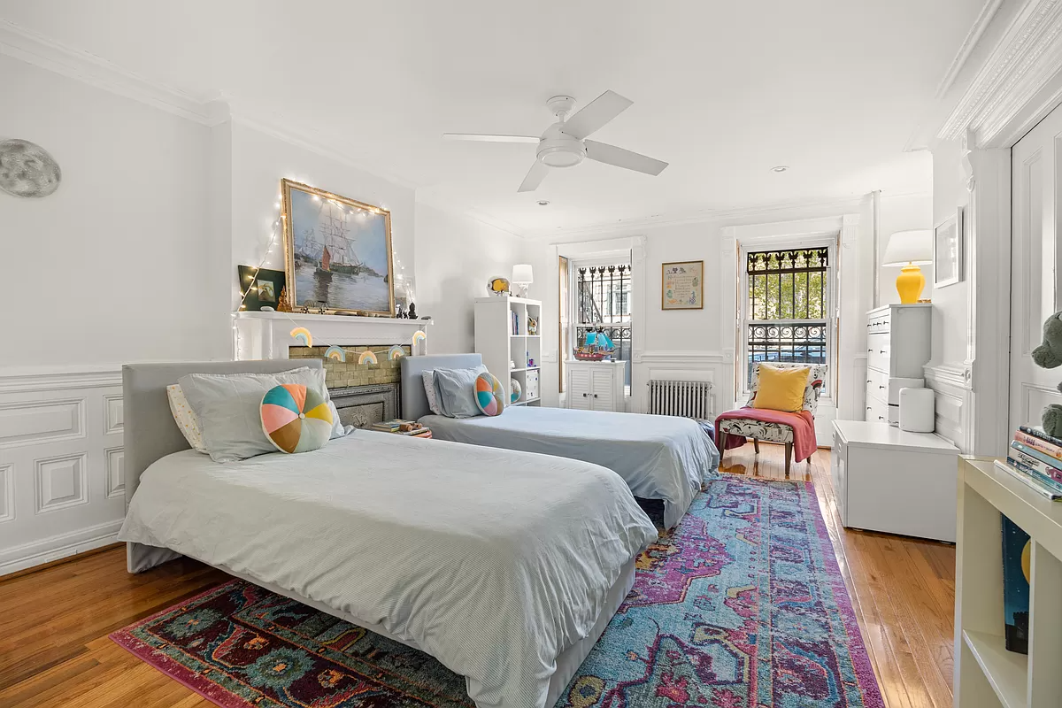 bedroom on the garden level with a mantel and wainscoting