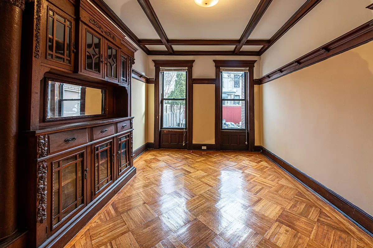 bedroom in former dining room with built-in china cabinet, beamed ceiling and plate shelf