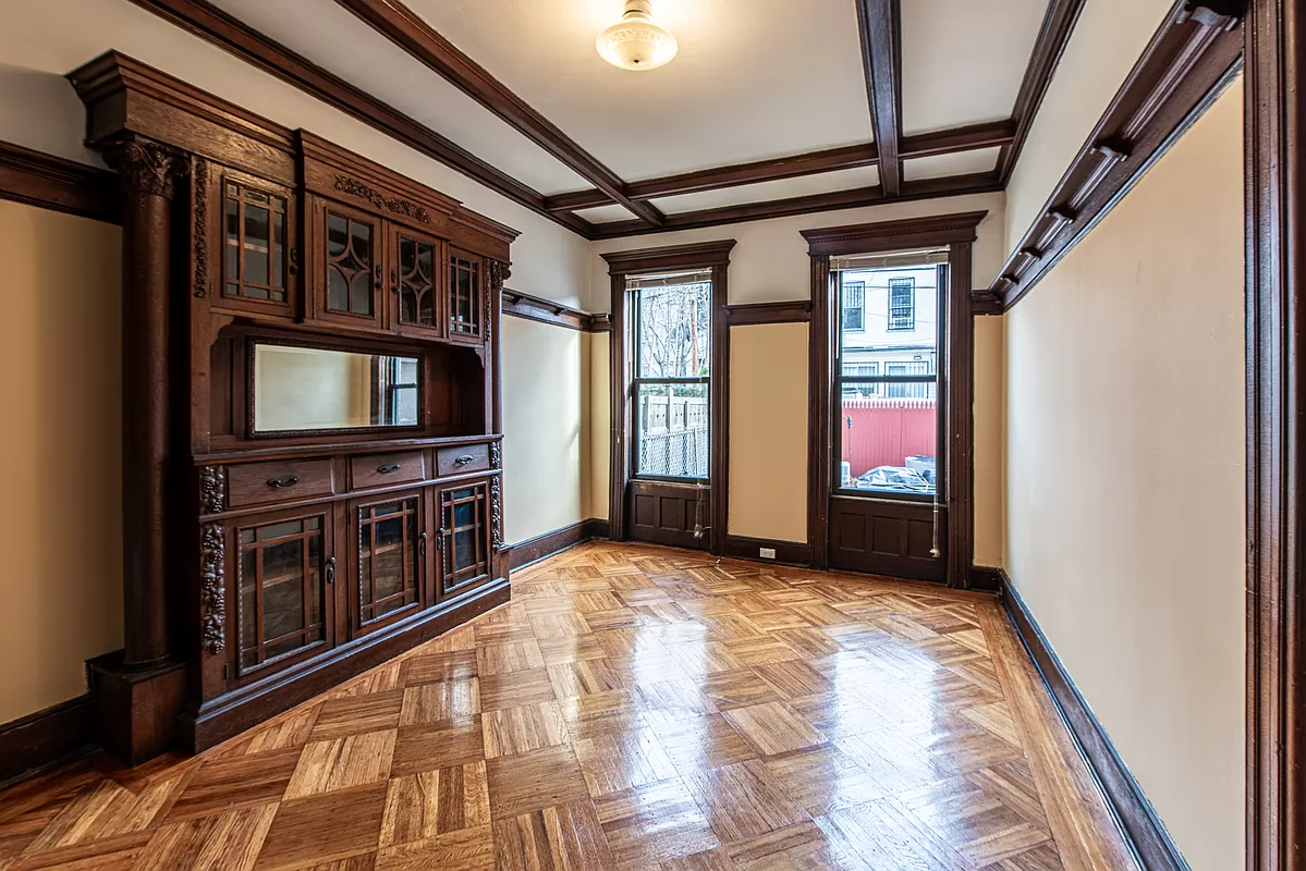 bedroom in former dining room with built-in china cabinet, beamed ceiling and plate shelf