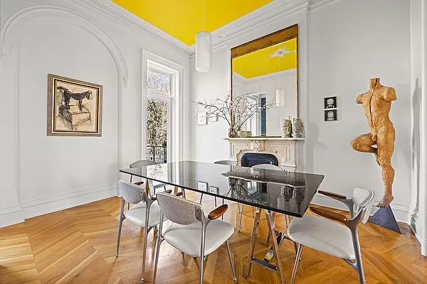 dining room with marble mantel and yellow ceiling