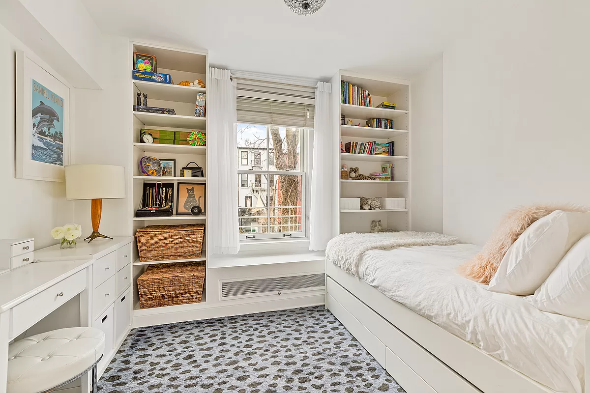 bedroom with built-in bookshelves on either side of a window