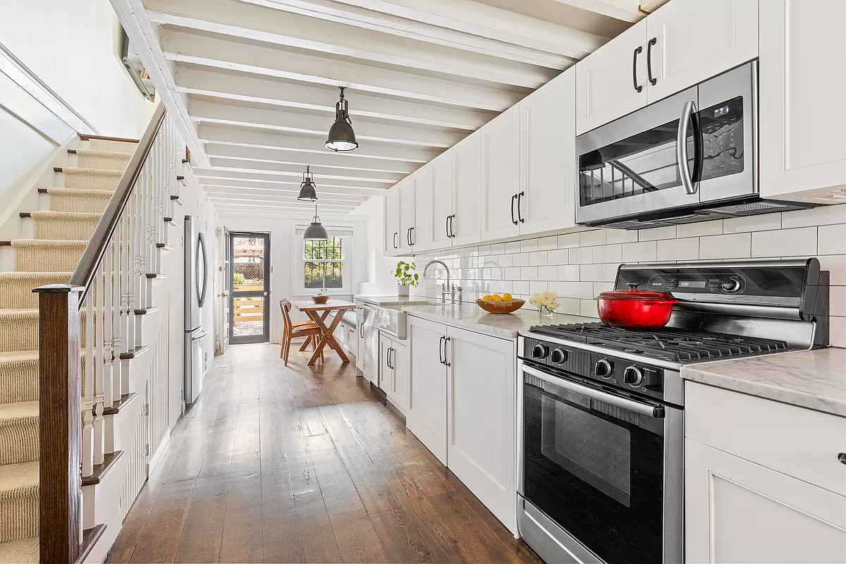 kitchen with beamed ceiling and white cabinets