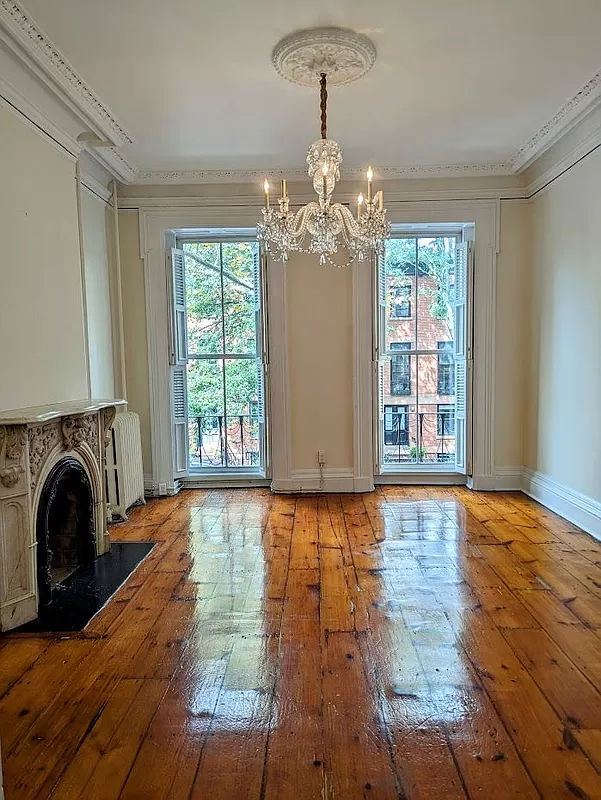 parlor with high ceilings, plaster details and a marble mantel