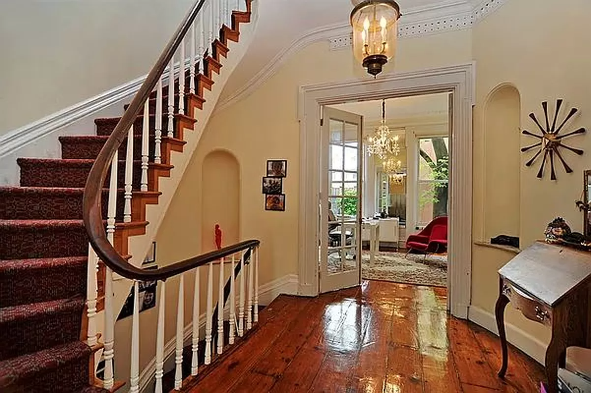 stair hall with niche, moldings and wood floor