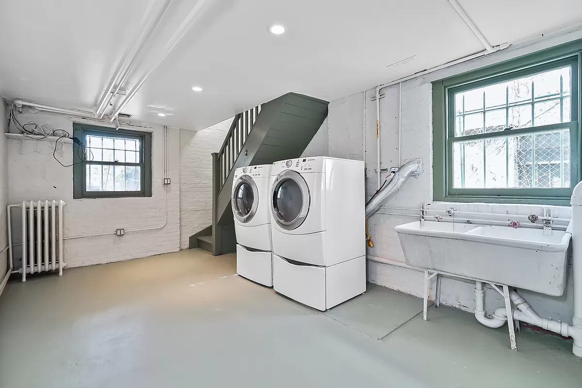 laundry area in the basement with a utlity sink