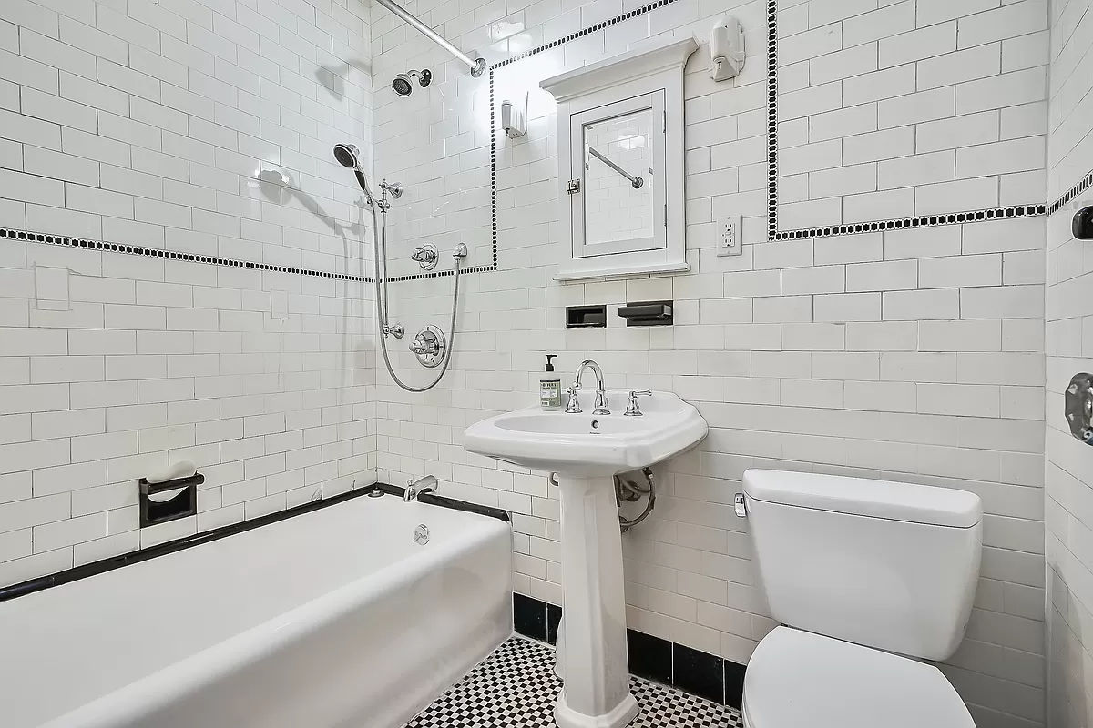 bedroom with black and white tile and white fixtures