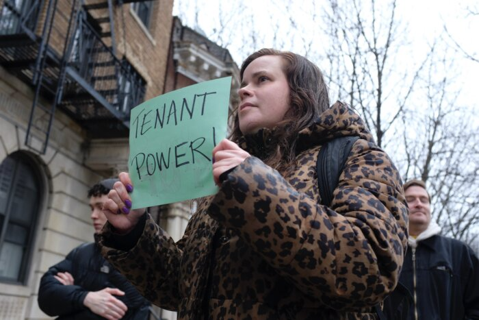 person holding sign with "tenant power" on it