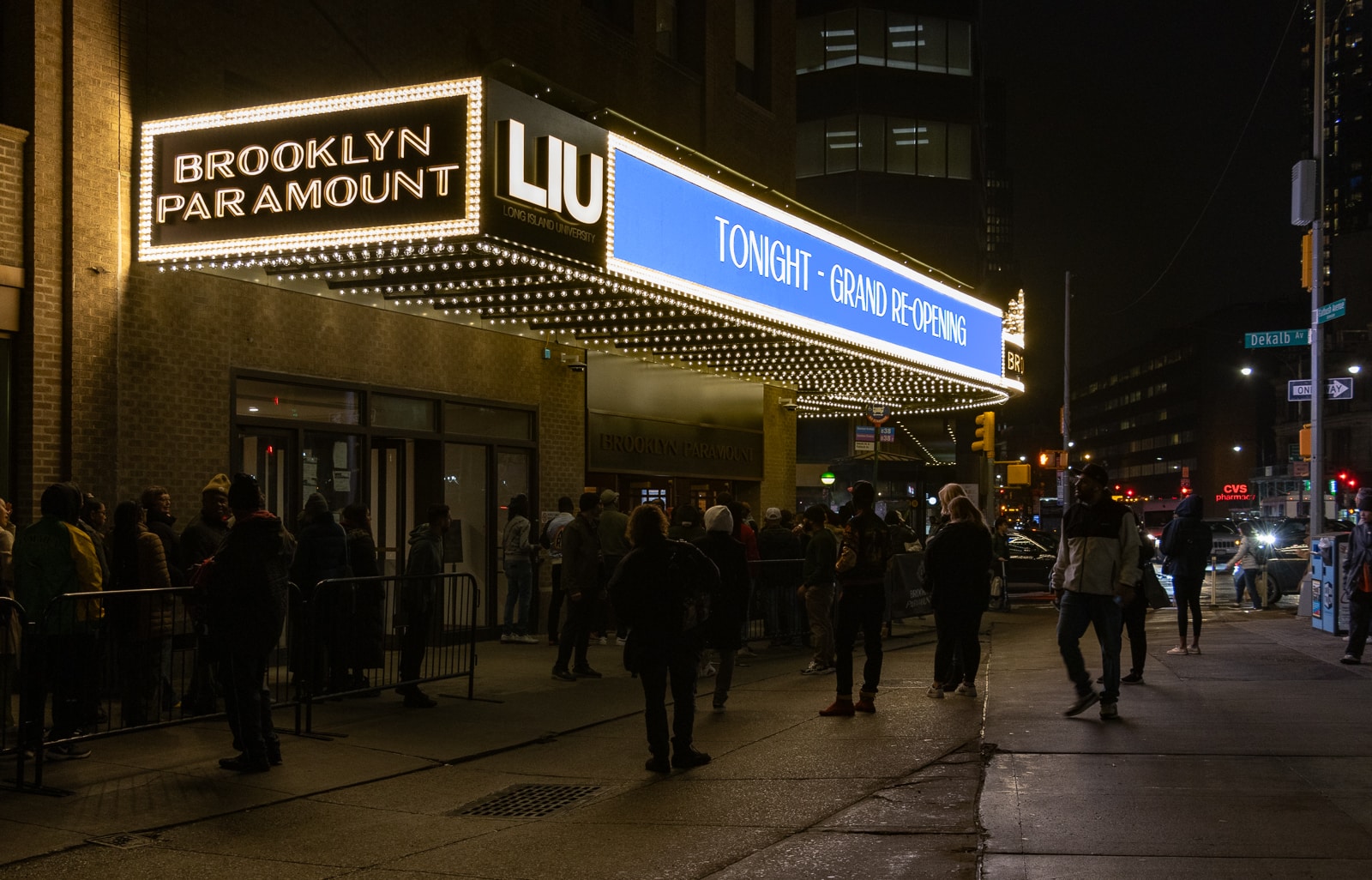 people online outside with the lit marquee above