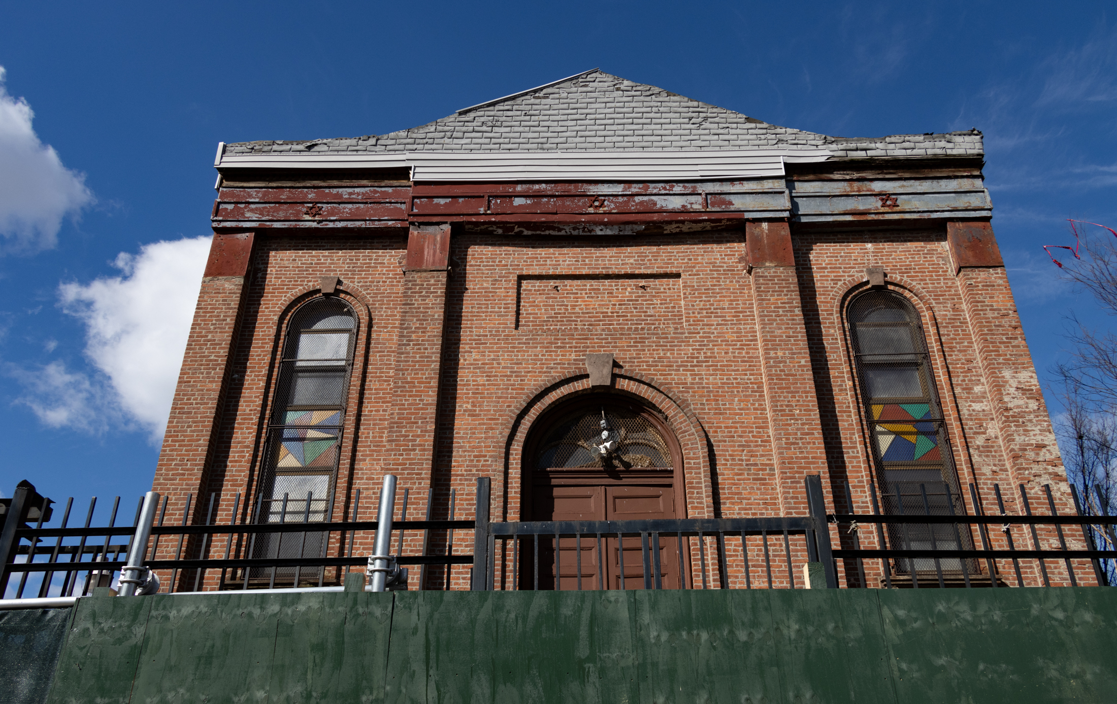brick church and former synagogue behind a construction fence