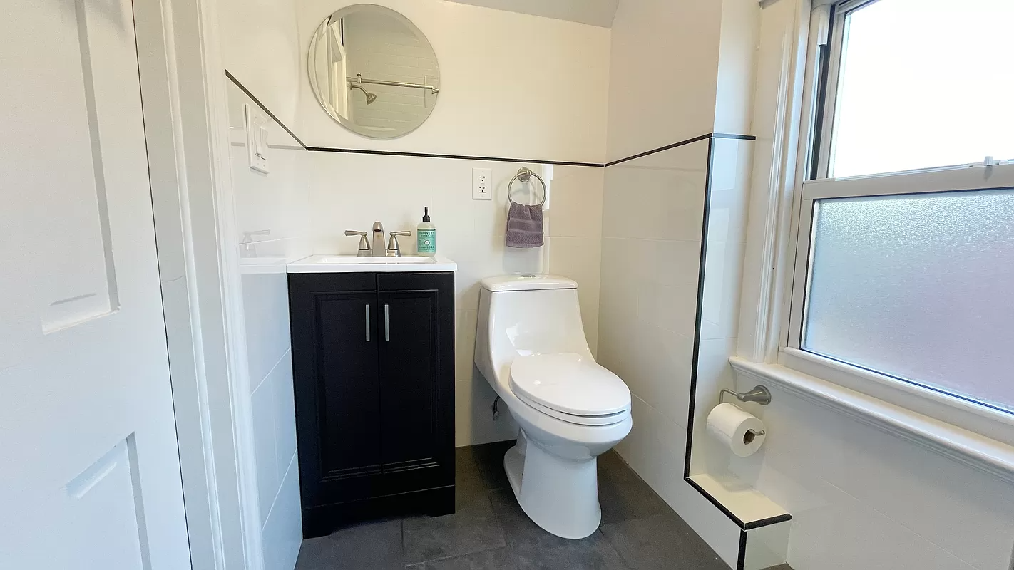 bathroom with white wall tile and white fixtures