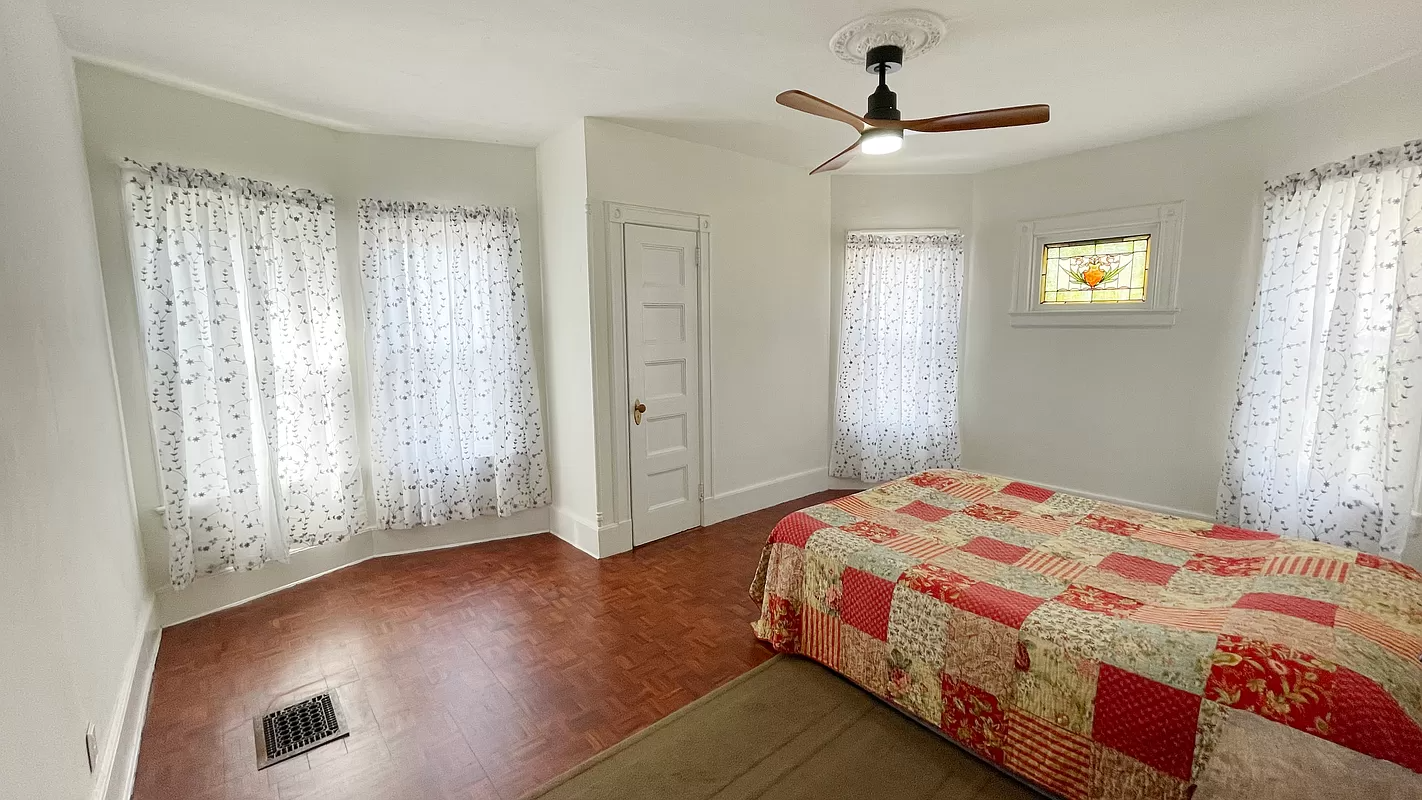 bedroom with multiple windows, stained glass window