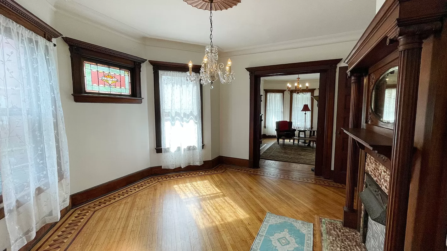 dinign room with columned mantel and stained glass window