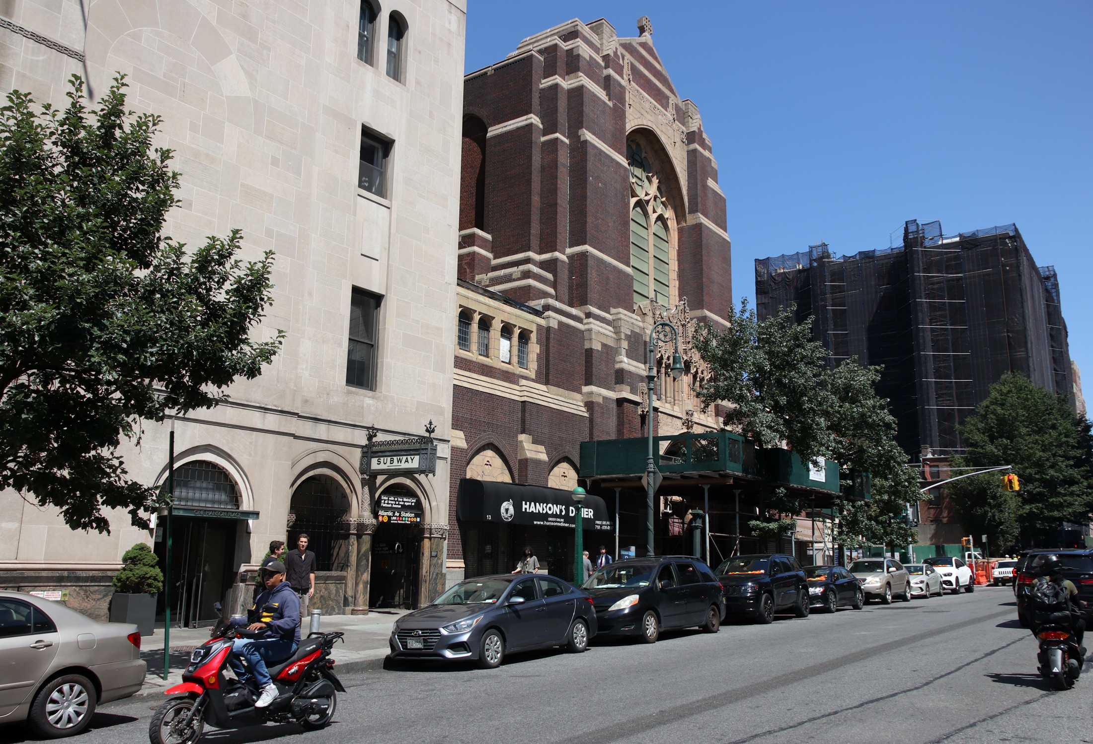 view on hanson place of the dark brick church next to a subway entrance in the williamsburgh savings bank