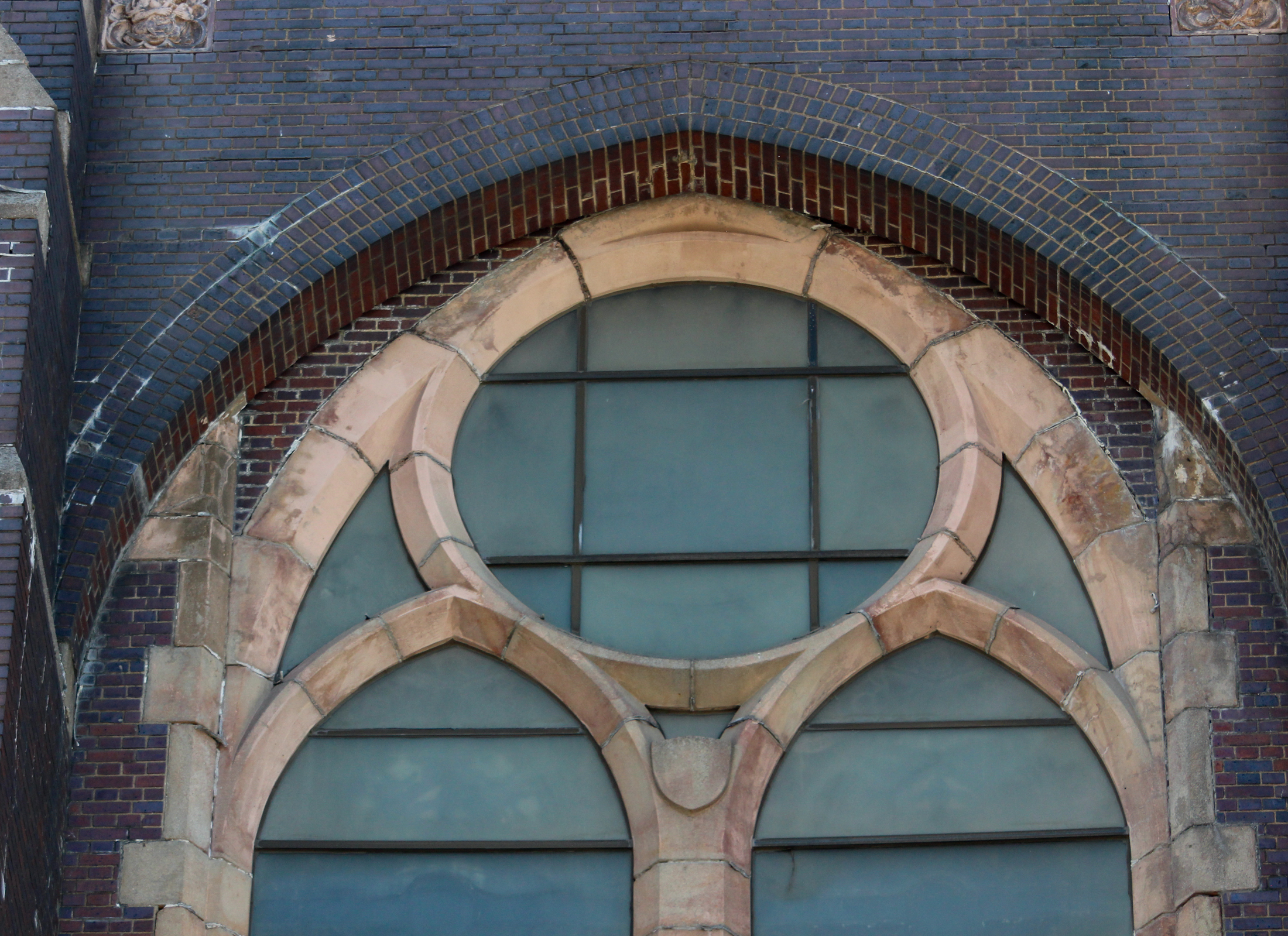 detail of a large window in the dark brick church
