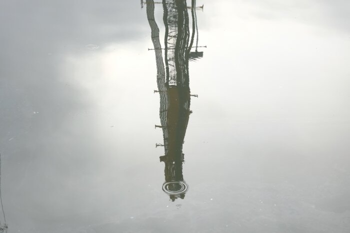 reflection of a construction crane in the canal