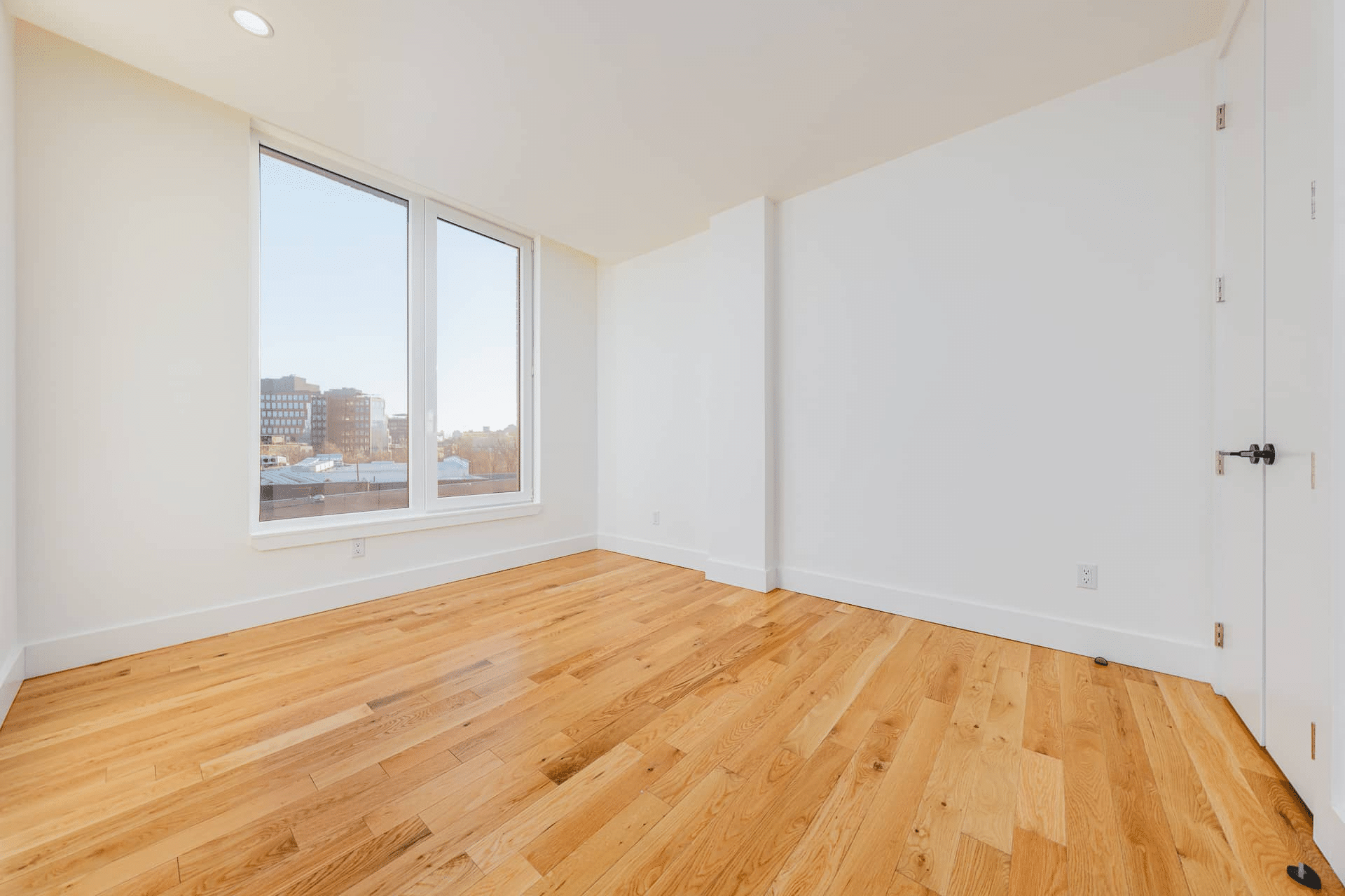 room with wood floor, white walls and recessed lighting