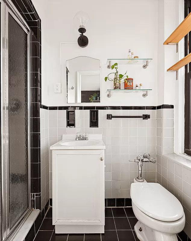 bathroom with gray and black wall tile and a built-in shower