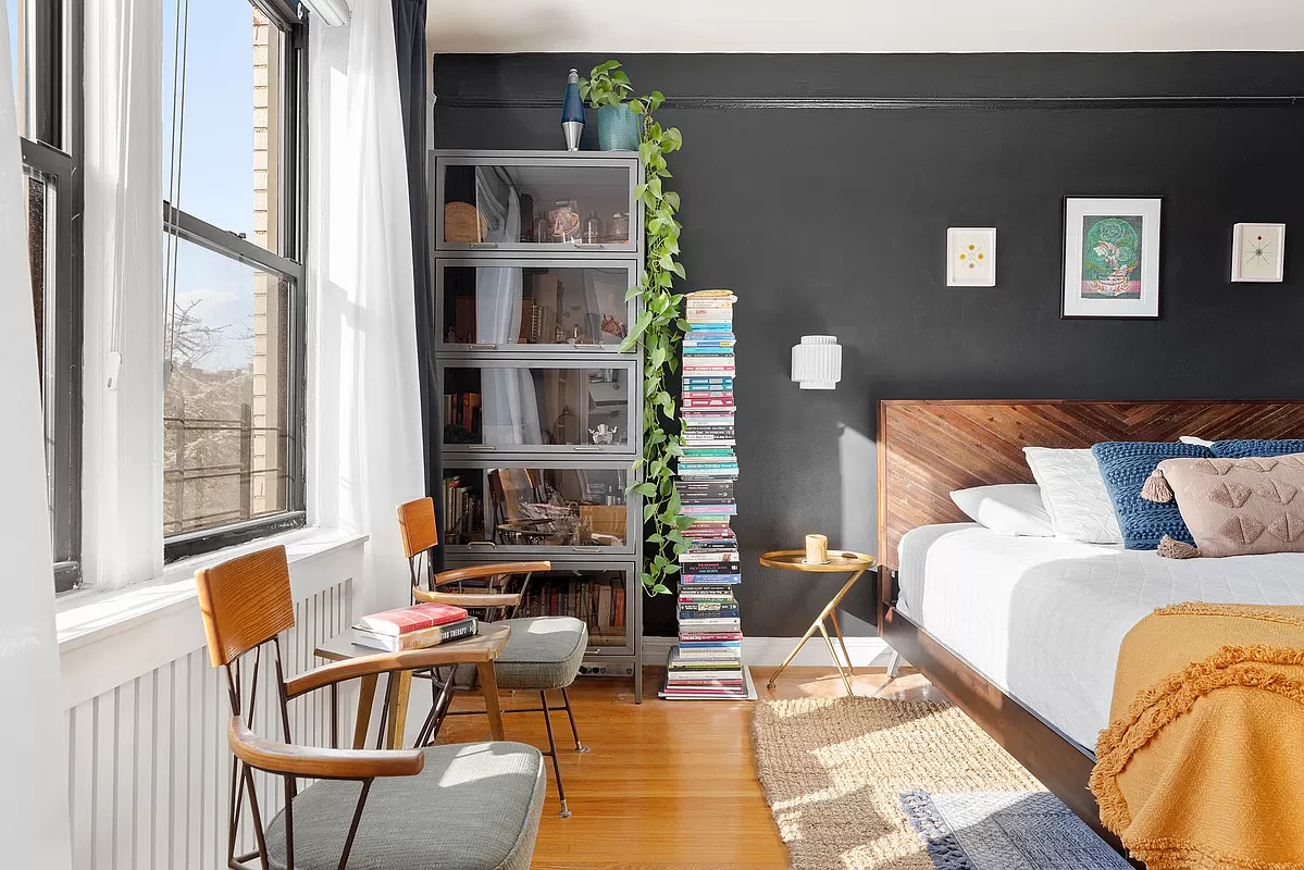 bedroom with wood floor, dark walls and picture rails