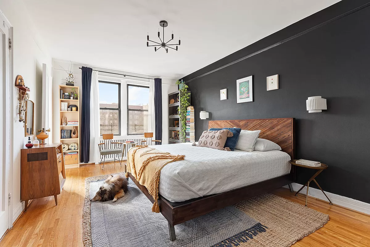 bedroom with one dark wall, picture rails and wood floor