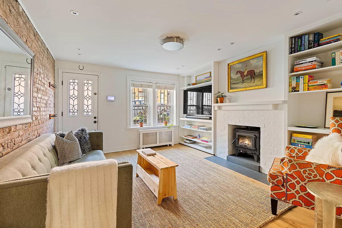 living room with exposed brick, fireplace and recessed lighting