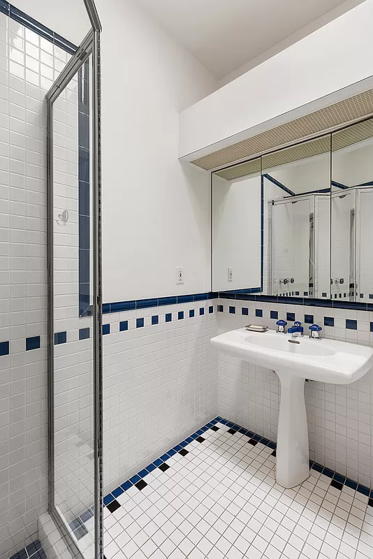 bedroom with white sink and shower with glass wall