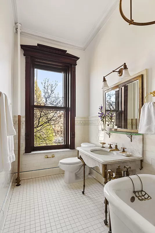 bathroom with marble sink, original border tile and a tub