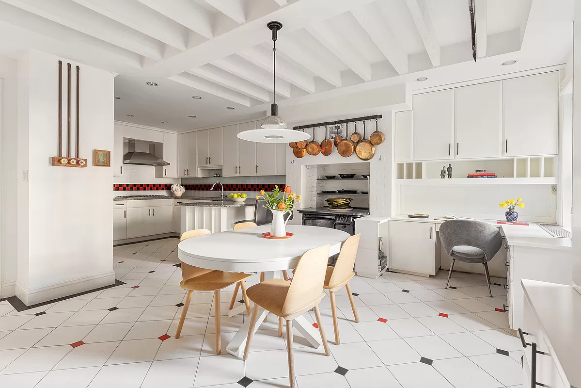 kitchen with white cabinets, exposed beams and white, black and red floor