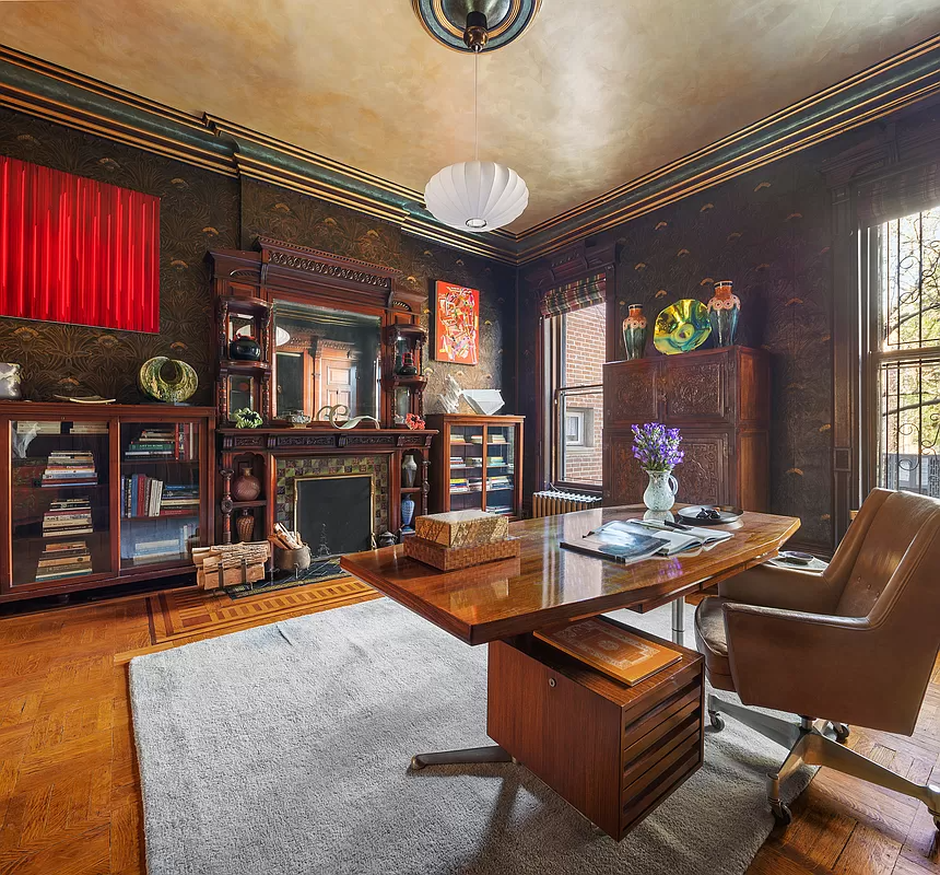 library with dark wallpaper and a wood mantel