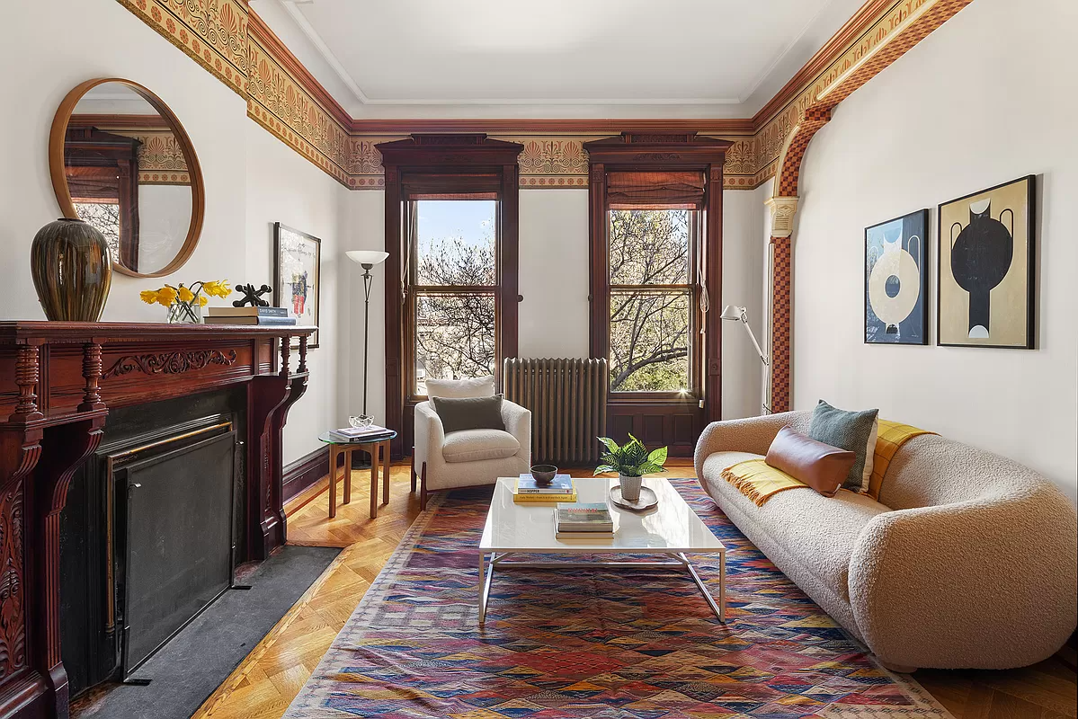 living room with wood mantel and wallpaper border