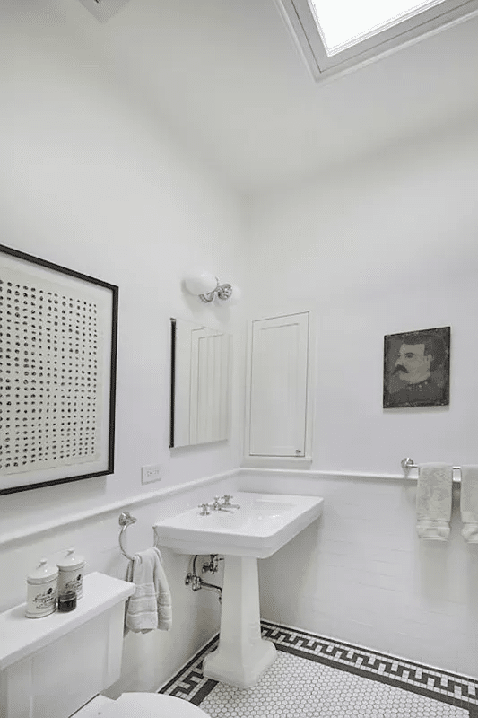 bathroom with black and white floor tile and a skylight