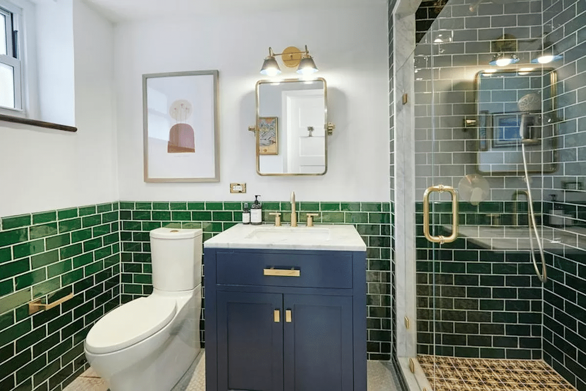 bathroom with green wall tile and a shower