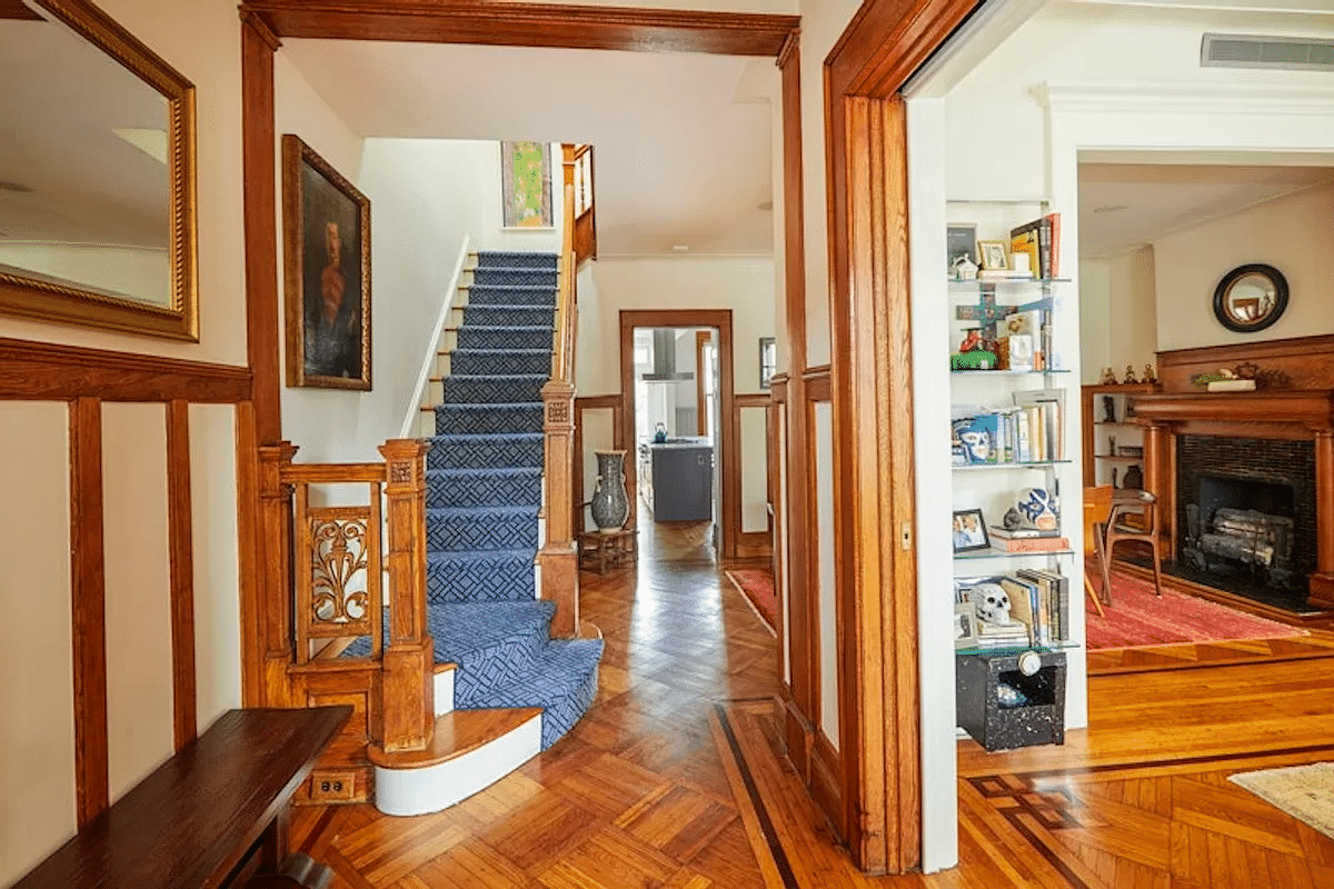 entry with wood floor and original stair with view into parlor