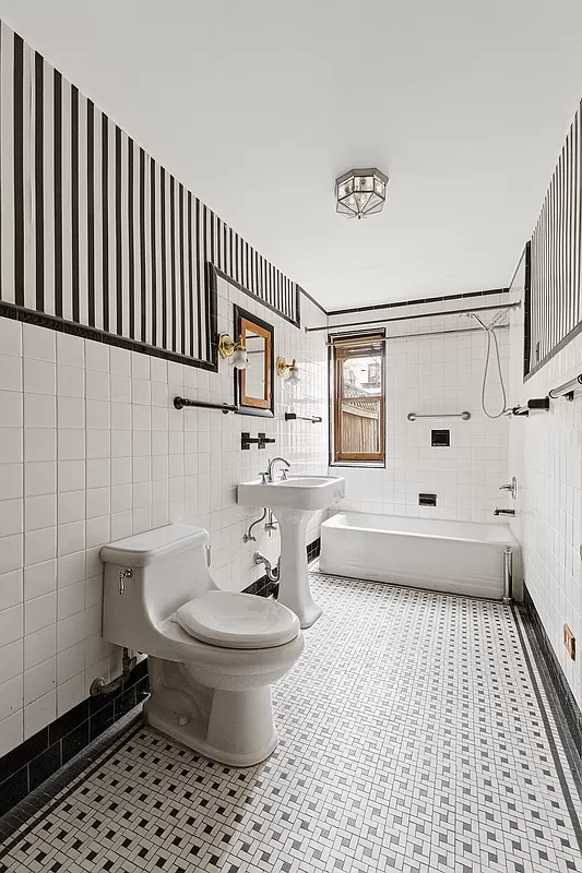 bathroom with black and white floor tile and white fixtures