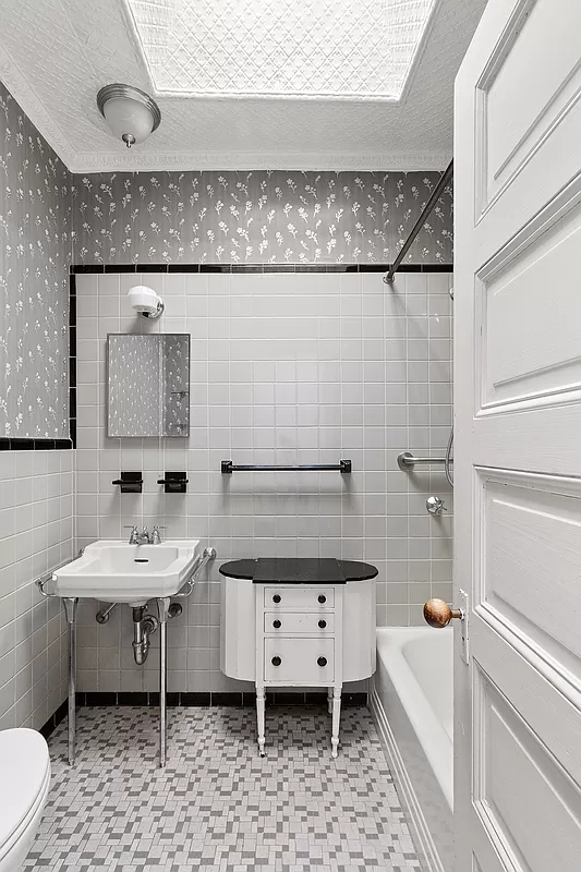 bathroom with gray and black floor and wall tile and a vintage sink