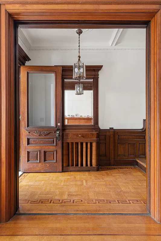 view to entry with wood floor, ceiling medallion and wainscoting
