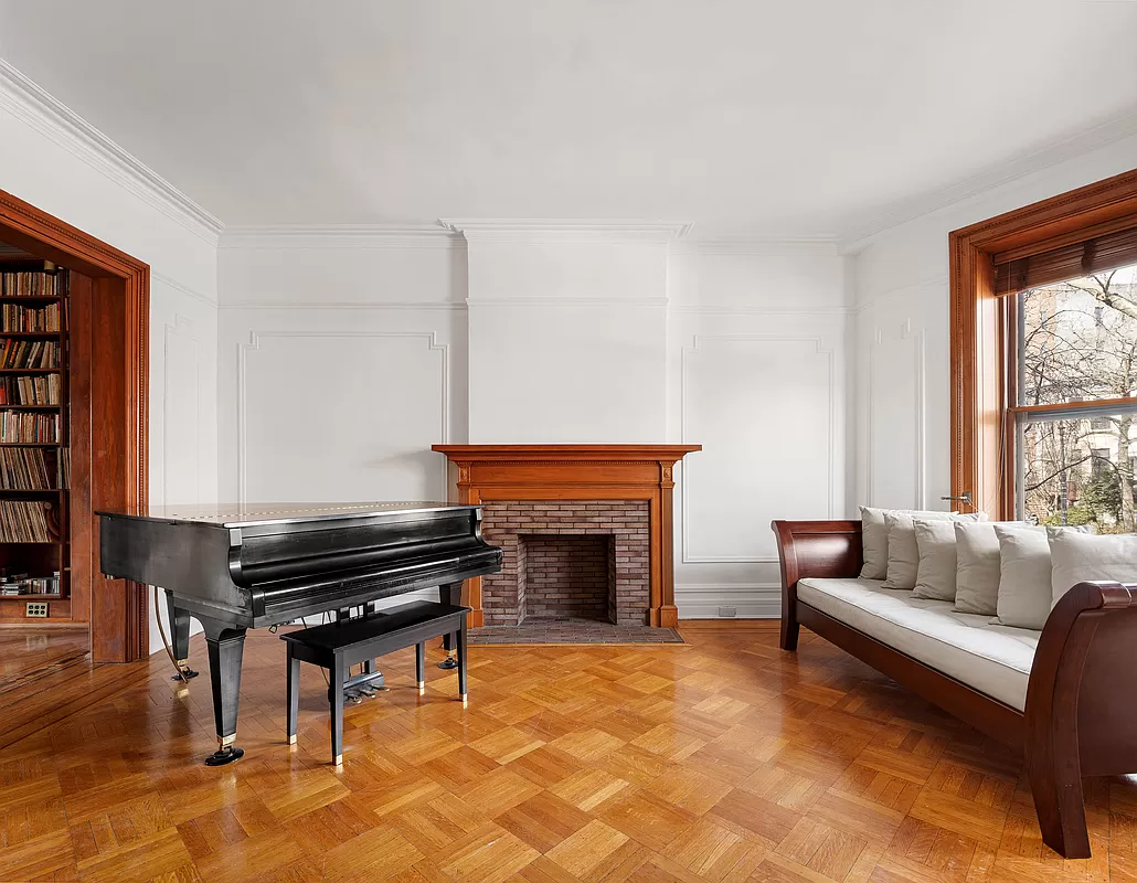 front parlor with wall moldings and a wood mantel