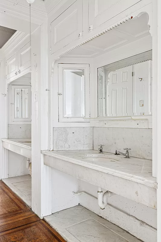 passthrough with marble sinks and white painted built-ins